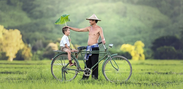 A man gives his son a ride on his bicycle.